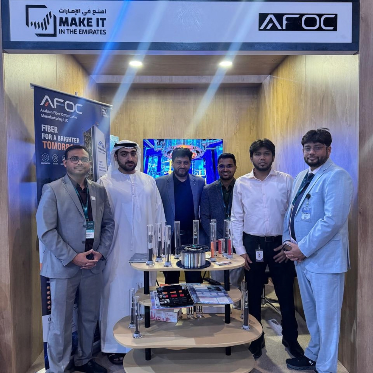 The AFOC team standing at the AFOC stand in the Make it in the Emirates area of the UAE Pavilion, with cable samples on display