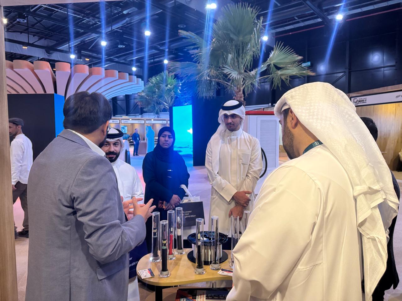 AFOC team member explaining fiber optic cable samples to a group of visitors